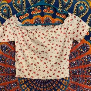 White off the shoulder crop top. Has red flowers on it.
